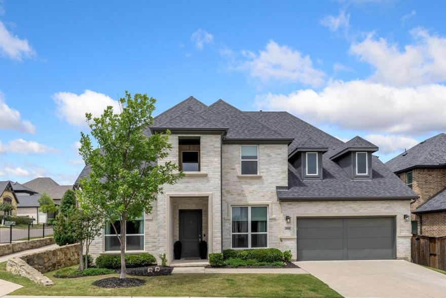 Welcome to 4000 Campania Court in the highly sought-after Creekside at Colleyville gated community, where modern luxury meets light, bright living. This beautifully maintained 4-bedroom, 5-bathroom home offers soaring 20-foot ceilings and an airy open layout that makes a statement from the moment you walk in. The grand entry flows into a stunning living space filled with natural light, oversized windows, and high-end finishes throughout, including a dramatic floor-to-ceiling stone fireplace with custom built-ins and designer touches that elevate the entire home. The chef’s kitchen is the heart of the home, featuring a large island, commercial-grade range, double ovens, butler’s pantry, walk-in pantry, and elegant quartz countertops—perfect for both everyday living and entertaining. A dedicated home office downstairs provides the ideal space for working from home or a quiet private study, while an additional first-floor ensuite bedroom offers excellent flexibility for guests or multigenerational living. The spacious first-floor master suite is a true retreat with a spa-like bath, dual vanities, soaking tub, separate shower, and oversized walk-in closet. Upstairs you’ll find a spacious game room, two secondary bedrooms with ensuite baths, a theatre room, and a dedicated home gym, offering incredible flexibility for both everyday living and entertaining. Thoughtful recent upgrades totaling approximately $60,000 include whole-home water filtration, HVAC and ducting improvements, UV air quality enhancements, extended stamped concrete patio space, backyard drainage improvements, and fresh landscaping. The 3-car tandem garage adds extra storage and functionality, while the gated community and prime Colleyville location provide convenience, privacy, and easy access to shopping, dining, and DFW Airport—offering the perfect blend of luxury, comfort, and everyday livability in one of Colleyville’s most desirable neighborhoods.
