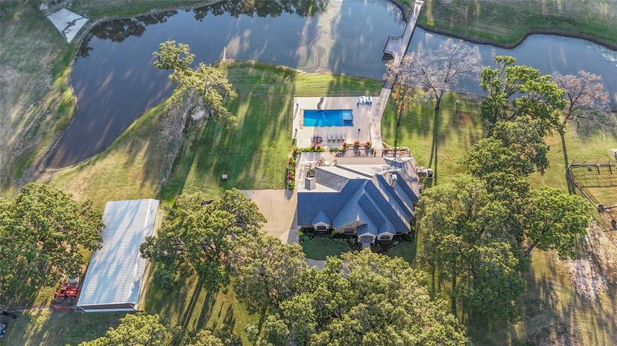 Welcome to luxury country living on 9 beautiful acres. This impressive 3876 SF brick home offers 3 spacious bedrooms, 3 bathrooms and an open concept design perfect for entertaining, beautiful custom cabinetry throughout, spacious living areas filled with natural light, a home gym, large bonus room with built in gun room, Generac in case you lose power. Every detail reflects quality and functionality. Step outside to your private retreat featuring a large heated and chilled party pool with spa and retractable cover that overlooks the stocked 1.5 acre pond with a custom steel bridge and attached dock wide enough to drive your ATVs across. The property is fully fenced with pipe fencing, gated entryway, concrete circle drive, a sprinkler system in all of your flower beds as well as one that waters all of the grass pumped from the pond. There is a dream 30 by 70 insulated shop with 5 inch slab and 200 AMP service. Custom 30 by 30 dog kennels with automatic heaters and water ran to each kennel perfect for animal lovers or breeders. There are RV hookups with a separate entry for your out of town guest to enjoy. This exceptional property blends comfort, recreation, and country charm offering the perfect balance of relaxation and functionality whether you're enjoying a quiet evening by the pool, working in your shop or fishing in the pond. Call today to schedule your private showing.