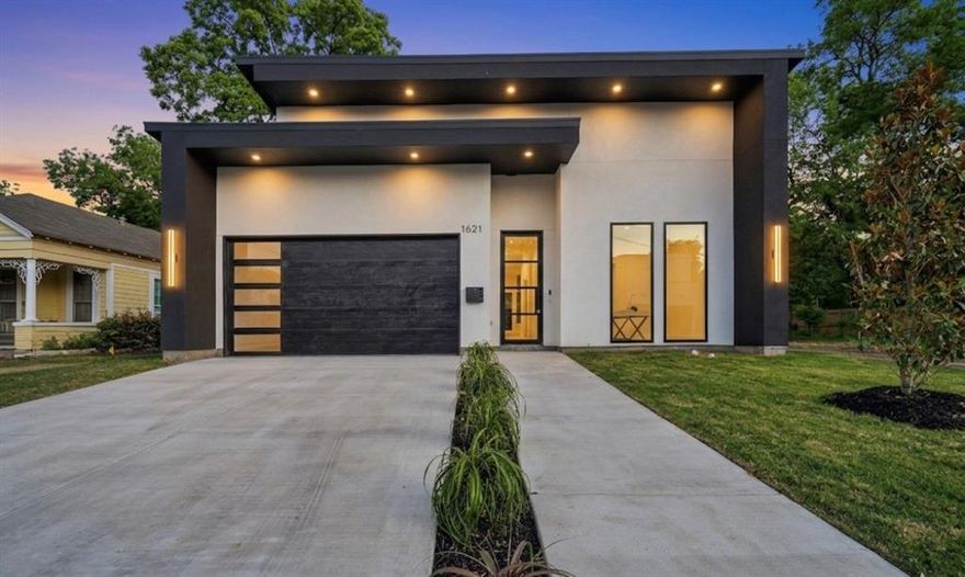Discover the perfect blend of modern luxury and peaceful living in this stunning South Dallas new construction. Situated at the end of a quiet street, this home offers exceptional privacy and an oversized lot while remaining just minutes from downtown dining, entertainment, and major conveniences. The striking black-and-white stucco exterior is enhanced by extensive architectural lighting, creating unforgettable curb appeal day and night.

Inside, the thoughtfully designed floorplan showcases soaring 10-foot ceilings, oversized single-panel core doors, and sound-resistant windows for a quiet, refined atmosphere. A dramatic 9-foot floor-to-ceiling fixed window floods the living space with natural light and creates a stunning architectural focal point.

The chef-inspired kitchen features sleek European-style finishes, an oversized waterfall island with built-in pull-out trash storage, a 33-inch Elkay sink, custom soft-close cabinetry, designer fixtures, and a natural gas range. Additional upgrades include a tankless water heater and discreet push-flush outlets that elevate both style and functionality.

The luxurious primary suite offers a true spa-like retreat with a custom walk-in shower featuring dual shower heads, a gold linear drain, and a designer tile accent wall. Modern conveniences continue throughout the home with an EV charging port, Ring doorbell, full security system, battery-backup garage door, dedicated side dog run, and a built-in dog wash station in the laundry room.

This exceptional home combines sophisticated design, premium finishes, and everyday functionality in one of South Dallas’ most desirable emerging areas.