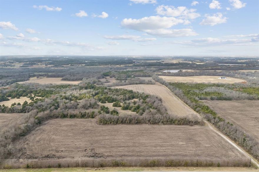 Encompassing 84.68 acres in Anna, Texas, this distinguished land offering presents a rare opportunity to acquire substantial acreage in one of North Texas’ most desirable and rapidly evolving markets. The property showcases a refined blend of open, usable land and native wooded areas, creating a landscape that is both functional and visually compelling. Maintained under a current Ag exemption, the property offers meaningful tax advantages while supporting agricultural operations, or long-term land stewardship. The open acreage provides an ideal foundation for a private ranch, luxury estate, or thoughtfully designed residential enclave, while the wooded areas contribute privacy, natural screening, and a serene rural ambiance. Positioned within Anna’s expanding growth corridor, the property benefits from close proximity to modern conveniences and infrastructure while preserving a sense of space and exclusivity. This tract is well suited for builders seeking premium land for future residential demand as well as discerning ranch buyers desiring scale, elegance, and long-term value. A rare North Texas land opportunity offering size, beauty, tax efficiency, and exceptional future potential. Roughly 8 Minutes to the brand new local WalMart in Anna and 16 minutes to the HEB & Buc-ee's. Also only about 45 Minutes to downtown Dallas, less than 20 minutes to major shopping centers, and medical needs. This ranch is for sale along with another 51 acres across the street see MLS# 21143125. Drone video tour available upon request.