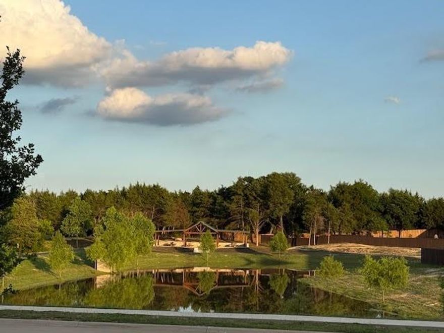 Located in the award-winning MIDLOTHIAN SCHOOL DISTRICT. Welcome to the Jackson floorplan built by BEST IN ELLIS COUNTY - JOHN HOUSTON HOMES in the highly sought-after Bryson Manor community. This thoughtfully designed 4-bedroom, 3-bath home offers a smart, functional layout with upscale finishes and space for everyone. Ideally positioned, the home faces the community pond and covered pavilion, offering peaceful lake views from the front porch, perfect for relaxing or enjoying the porch swing. Inside, you’ll find 8-ft. doors, soaring ceilings, rich wood flooring, and custom-painted cabinetry extending to the ceiling. The bright, open kitchen features a striking wood-wrapped island with sink and quartz countertops and flows seamlessly into the spacious living area, ideal for entertaining or everyday living. The living room showcases dramatic ceilings and a 42-inch wood-burning fireplace with floor-to-ceiling stone and elegant tilework. The main level includes a private study, formal dining room, and two full bedroom suites. The primary suite offers dual sinks, a large walk-in shower, soaking tub, and spacious walk-in closet. A separate guest suite includes a full bath with wood vanity and tub-shower combination. Upstairs, a large game room and media room provide flexible space for movie nights, play, or relaxation. This home is move-in ready with upgraded carpet and tile, window blinds, an extended covered patio, and Low-E film on front and side windows for energy efficiency. The oversized covered back patio overlooks a fully fenced backyard backing to open land—no rear neighbors—and includes a storage shed, with room for a future pool (rendering shown). Additional features include a hammerhead driveway allowing space to add a third garage bay. The laundry room offers built-in cabinetry, a drying rack, and space for a refrigerator. Enjoy country living just 25 minutes from Arlington, approximately 35 minutes to downtown Dallas, and close to shopping and dining.