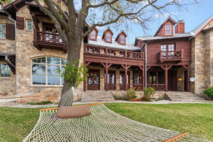 Majestic Oaks grace this Stone and Timber Luxury Estate in the Ranch. Hand scrapped wood floors and custom pegged mortise construction. European Craftmanship in this spacious 7 bedroom, 6.5 bath with bunkroom that sleeps 8.  Stunning views from every room. Wood burning fireplace, vaulted ceiling, large island kitchen with built-in appliances.  Butler pantry, ice maker, 2 refrigerators, dog run and outdoor cooking area. Relax on the balcony or deck listening to waves hit the beach.  Detached 3 car garage with storage above. A wooded greenbelt area is adjacent to the property adding privacy to the gentle slopping lot with easy walk to your own private dock. Property has been freshly painted.   Ranch amenities include stables, swimming pool, ATV trails, skeet shooting range, fitness center, boat ramp, and 1100 acres of common area.  Purchase of this house includes the option for Buyer to have a slip at  Patterson PK Marina instead of a 3 to 5 year waiting list.