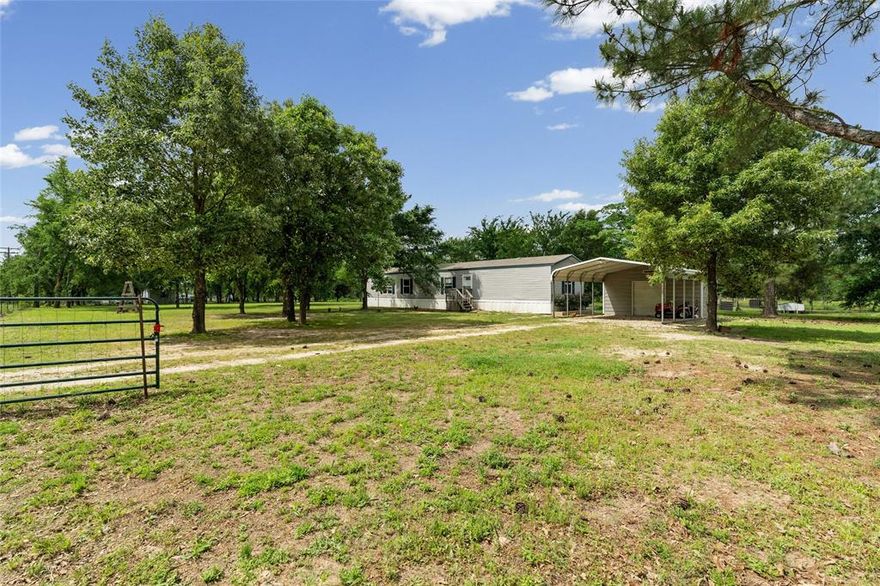 Tucked away in a quiet East Texas setting, this property offers a great mix of open space and mature trees, giving you room to spread out without feeling exposed.  The land is mostly level and usable, with scattered shade trees throughout ideal for everyday living, animals, or just enjoying the outdoors. There’s plenty of space to add improvements, expand, or simply keep it as a peaceful homestead.
The home sits back off the drive and is complemented by a covered carport and additional storage, giving you practical functionality right from the start. The yard is open enough for easy maintenance but still has enough tree cover to create a private, relaxed setting.
You’ll also notice features like the elevated structure and playhouse and open yard areas, which add flexibility depending on how a buyer wants to use the space. Overall, this is the kind of property that works well for someone looking to get out of town, have a little space, and not feel boxed in while still being within reach of Emory and surrounding areas.