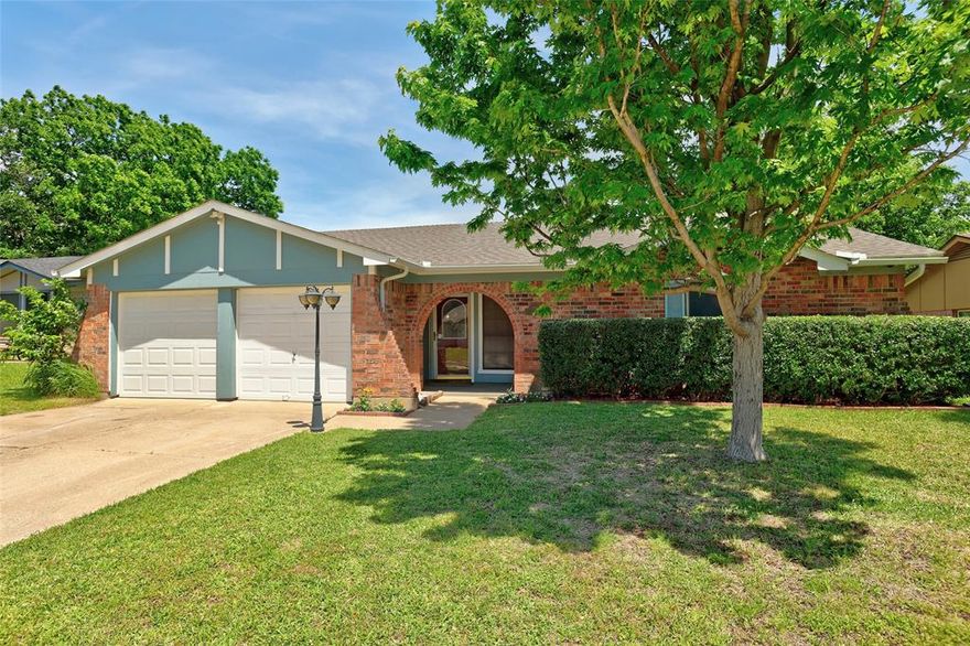 Welcome to this beautifully updated home. The only 4-bedroom, 2-bath home on the street in the desirable Spring Meadow addition in Arlington! From the moment you arrive, you’ll notice the charming curb appeal with mature trees, a covered front porch, and a welcoming entry. Inside, the home features fresh paint and updated flooring throughout, creating a clean and modern feel. The kitchen is bright and open with granite countertops, stainless steel appliances, a smooth electric cooktop, built-in microwave, subway tile backsplash, and ample cabinet space. It flows seamlessly into the main living area, making it perfect for everyday living and entertaining. The spacious living room offers a cozy stone wood-burning fireplace, ceiling fan, and great natural light, with French doors leading out to the backyard. The primary suite includes a walk-in closet and separate vanities, while the additional three bedrooms all feature ceiling fans for added comfort. Step outside to enjoy a covered patio overlooking a nicely sized, fenced backyard with mature trees and a detached storage shed that has electricity—ideal for workshop or hobby space. With thoughtful updates, a functional layout, and inviting indoor-outdoor spaces, this home is move-in ready and full of charm. Minutes away from AT&T Stadium and The Arlington Highlands and walking distance to Elementary and Middle School.   For a showing or virtual tour text TDT#54 to 88000