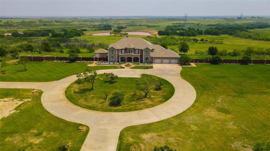 SELLER WILL CONSIDER SELLING HOME WITH LESS ACREAGE! This immaculate plantation style home is ready to go. Gorgeous open concept, MIL suite, media room, game room, 7 bedrooms, 5 bathrooms, 2 laundry rooms, and an infinity pool with a hot tub and cabana with kitchenette. 30x60 barn has 9 stalls perfect for horses. Largest pond is over one-half acre, 25 ft deep and is spring fed. Enjoy the sand volley ball bit for hours of family fun. Located less than 2 hours from Will Rogers Coliseum in Ft Worth. TURN KEY WITH MOST OF THE FURNISHINGS CONVEYING!
