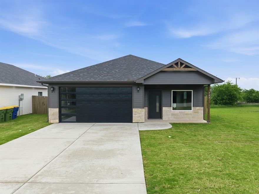 Elevate your living with a custom built home by True Hands Construction. Timeless design meets modern sophistication.  Every detail has been carefully selected to impress from the real wood pine siding to custom built cabinetry. Every inch reflects exceptional craftsmanship and elegant detail.  Step into a spa inspired primary suite featuring a frameless glass shower wrapped in wall to ceiling tile and a pebble stone floor, pocket doors, and a walk in closet-a retreat designed for comfort and style.  Impeccably crafted kitchen that's warm and inviting with elegant touches featuring an oversized stone top island, custom vent hood, pot filler, custom cabinetry with built in trash cabinet and microwave. The home's real wood pine siding, stone accents, and modern lighting create a striking curb appeal, while the fenced in back yard with sod offers a private sanctuary.  Even the epoxy coated garage floor speaks to the commitment of quality in every detail. Hillsboro is an up and coming community that delivers closeness of community and convenient location close to I-35 making an easy commute!