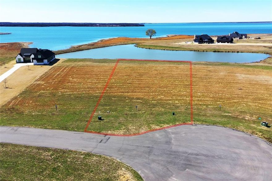 Discover the essence of lakefront living on this generous 1.4 acre homesite with waterfront views. Picture your mornings on your own fishing pier as this site is both fishing pier capable and also has a deeded boat slip at the marina. This standout lot is the perfect foundation for your custom lakeside dream home—plenty of room to build, add a boat garage, and create memorable outdoor gathering spaces. Inside this exclusive gated community you’ll enjoy resort-style amenities, including a stunning multi-million-dollar clubhouse with an infinity-edge pool, top-tier fitness center, and a putting course. Whether you’re planning your forever home, a weekend escape, or an income-generating short-term rental, this property checks every box. Short-term rentals are allowed with very few restrictions.