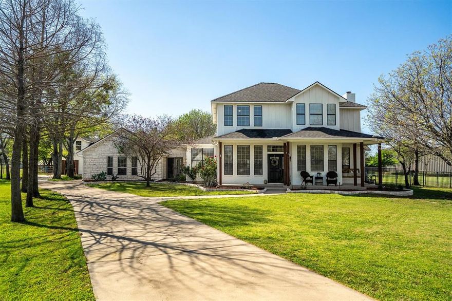 Nestled in the heart of Argyle, TX and zoned for the highly sought-after Argyle ISD, this charming farmhouse offers the perfect blend of peaceful country living and modern comfort. A long, private driveway leads you to a welcoming front porch, ideal for enjoying quiet mornings and Texas sunsets. Step inside to discover a warm and inviting kitchen, featuring ample cabinetry, beautiful granite countertops, and plenty of prep space. The home offers both a formal dining area and a designated breakfast nook, creating flexibility for gatherings large and small. The main living room is truly the heart of the home, showcasing soaring ceilings, a cozy fireplace, and an open, airy feel. The primary suite provides a serene retreat, complete with a spacious ensuite bathroom featuring dual sinks, a jetted tub, and generous counter space, perfect for relaxing and unwinding. The thoughtfully designed downstairs layout includes two additional bedrooms and a full bathroom with dual sinks, along with a dedicated home office. A standout feature is the massive family room, rich with natural woodwork, a grand wood-burning fireplace, and ceiling fan, perfect for cozy nights in or hosting guests. The hallway offers a built-in desk area and a functional mudroom that leads to an impressive 4-car garage with abundant storage. Above the garage, a game room provides the ultimate space for entertaining, game days, and making lasting memories. Upstairs, you’ll find two additional bedrooms connected by a convenient Jack-and-Jill bathroom, offering comfort and privacy. Step outside and experience your own private oasis. The expansive backyard boasts a sparkling pool, covered patio with an outdoor kitchen, and a fire pit, perfect for entertaining year-round. Additional features include a large garden, chicken coop, workshop, and plenty of open space for pets, animals, or simply enjoying the outdoors. Workshop plans are available to show potential mother-in-law suite remodel.