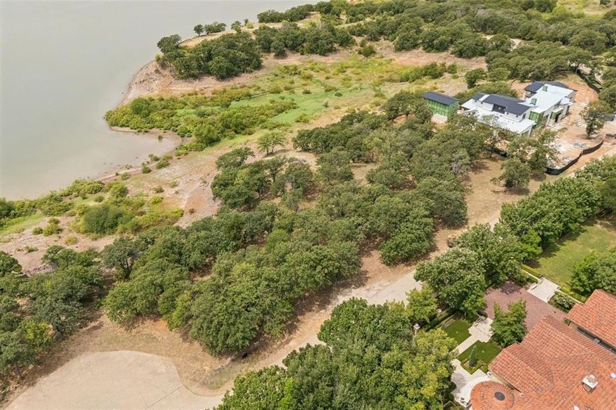A Once-in-a-Lifetime Opportunity Awaits! Discover this extraordinary, nearly 2-acre LAKEFRONT lot tucked at the end of a quiet cul-de-sac in the prestigious, gated community of The Landing—within the highly acclaimed Flower Mound ISD. Perfectly blending privacy, exclusivity, and convenience, this property offers the rare chance to create your custom luxury estate in one of North Texas’ most coveted locations. With unobstructed, panoramic views of Lake Grapevine, this homesite promises a lifestyle defined by serenity and natural beauty. Imagine waking up to breathtaking sunrises, savoring spectacular sunsets from your own backyard or future balcony, and enjoying the calming presence of water year-round. Only 25 minutes from DFW International Airport and moments from major highways, shopping, dining, and renowned schools, you’ll enjoy a secluded lakeside retreat without sacrificing city conveniences. Acreage of this size directly on Lake Grapevine is exceedingly rare—especially with views of this magnitude. Full architectural plans for a custom-designed residence by Stewart Custom Homes are available, offering an unparalleled opportunity to bring your vision to life in a setting worthy of your dream.