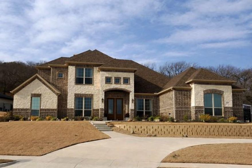 Exquisite WATERFRONT LUXURY in the gated LAKE RIDGE community of Cedar Hill, zoned to Midlothian ISD. This stunning 4-bedroom, 5 full-bath, 3 Car Garage home offers exceptional design, premium finishes, and resort-style living. A grand double-door entry opens to breathtaking pond and fountain views, soaring 10-foot ceilings, and abundant natural light.

The gourmet chef’s kitchen features luxury Signature appliances, built-in refrigerator, six-burner gas range, double ovens, convection oven, microwave (four ovens total), propane gas, pot filler, Corian countertops, 42-inch cabinetry, and glass-front uppers. Open-concept living includes in-floor outlets, a stone wood-burning fireplace, and seamless indoor-outdoor flow.  More photos to be uploaded

The primary suite is a private retreat with French doors opening to a heated pool, spa, and fountains. The spa-inspired bath offers an oversized wet room with walk-in shower, garden tub, and custom walk-in closets with built-ins.

Enjoy a dedicated media room with riser seating, surround sound, wet bar, and projector-ready setup, plus a private office, large laundry room (12x7), and pool-guest bath. Outdoor living includes a fully equipped kitchen, ceiling fans, speaker prewire, exterior outlets, artificial turf, and extended tree-lined land beyond the wrought-iron fence.

Additional features include a 3-car MyQ garage and gate accessible, generator-ready setup, security cameras, custom blinds, luxury vinyl plank flooring (carpeted bedrooms), 500 sq ft upstairs build-out potential, and mostly ensuite bedrooms. A rare waterfront opportunity in one of Cedar Hill’s most sought-after gated communities.