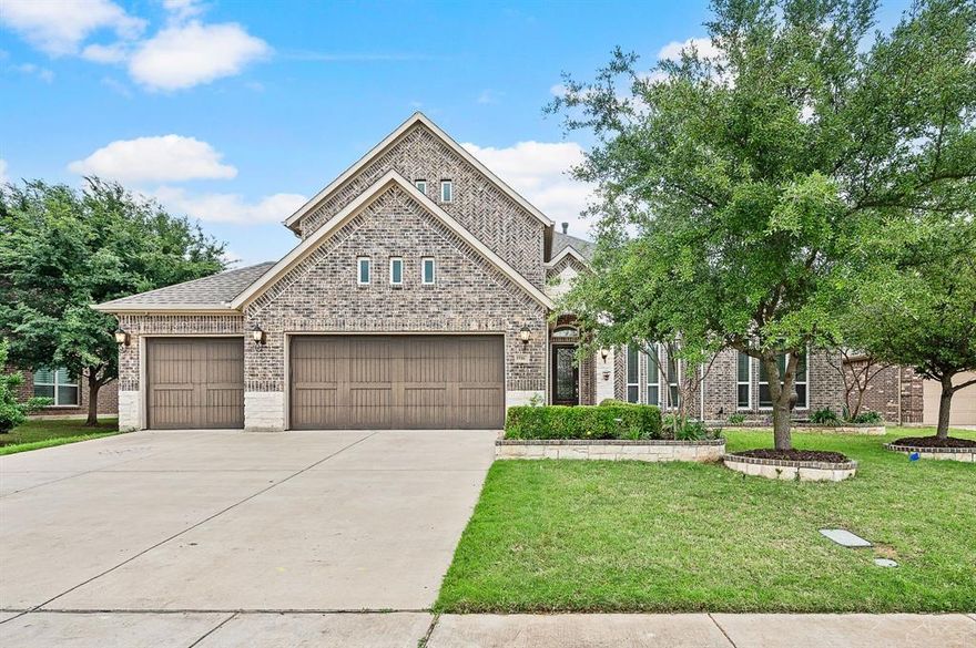 Welcome to this beautifully crafted home built by Harwood Homes, this stunning residence blends timeless design with thoughtful upgrades throughout and Corinth Butterfly park conveniently located right behind the home. A striking stone arch and upgraded front door create an inviting first impression, while the three-car garage with SmartSide doors adds both style and functionality. Inside, rich hardwood flooring flows through the main living areas, including the living room, dining room, kitchen, nook, and hallways, creating a warm and cohesive feel. The open-concept layout is complemented by a dramatic curved staircase and a well-appointed butler’s pantry featuring elegant upper glass cabinets. The kitchen showcases upgraded granite countertops, Shaker-style cabinetry, and quality finishes, perfect for both everyday living and entertaining. Designed for comfort and flexibility, the home offers two bedrooms downstairs, ideal for guests or multi-generational living. The primary suite features granite countertops, rectangular wave sinks, and framed mirrors, along with satin nickel plumbing and lighting fixtures that carry throughout the home for a polished look. Additional highlights include upgraded carpet on the stairs with a hardwood starter step and a spacious covered patio for outdoor enjoyment. Enhanced with a Savant whole-home automation system, this home delivers modern convenience alongside exceptional craftsmanship, truly a standout property with attention to every detail.