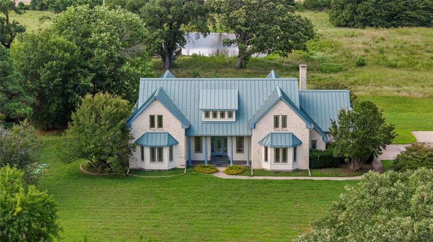 This exquisite two-story stone residence blends timeless elegance with modern comfort. Boasting 5 spacious bedrooms and 4 bathrooms, this home features upscale finishes and thoughtful design throughout. A detached 3-car garage with a concrete drive and additional 2 car garage space attached to the home provides ample vehicle space and storage convenience, while the 15 Acres of landscaped grounds create an inviting ranch setting. This property has covered patio with tile floor over looking the private pond offering a stunning view, complete with a deck perfect for new owner. This well-appointed home is filled with an abundance of windows that bathe the interior in natural light and offer picturesque views of the pond. Thoughtful built-ins and custom details are found throughout, including fireplace that add warmth and ambiance to the den. The kitchen showcases natural wood cabinetry, tile countertops, and a cozy eat-in breakfast area framed by bay windows. Upstairs, you'll find three spacious bedrooms, two full baths, along with a versatile bonus room featuring extensive built-in storage and an office area perfect for working from home.  A rare combination of luxury, space, and natural beauty—ready to welcome you home.