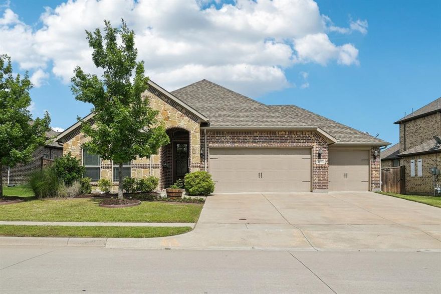 SELLER OFFERING $9,000 BUYER CREDIT TOWARDS INTEREST RATE BUY DOWN! Hard-to-find 3-CAR GARAGE in a single-story home built by Windsor Homes, the highest quality builder in Anna Town Square! Feel the difference when you enter through the 8-foot custom door and walk through the wide entry and hallway to experience high ceilings and a well-appointed living area. The open floor plan is inviting and spacious, with plenty of natural light from the wall of windows across the back of the home. The kitchen has custom-built, hand-stained wood cabinetry with 42-inch uppers, beautiful granite countertops, stainless steel appliances, a dishwasher, a gas range, and a microwave oven vented to the outside. The pantry is spacious and offers ample storage. The stainless steel refrigerator will stay with the home! The living room features a corner-mounted 36-inch, direct-vent gas log fireplace with cast-stone style mantle. With just a flick of a switch, you can light the fireplace and enjoy its beauty and warmth! The living room also features in-ceiling speakers and surround sound wiring with panel access at the wall for your electronics. There is plenty of space on the wall for most larger flat panel TV screens. Through the oversized dining room, you can access the covered back patio and enjoy the large backyard with a 6-foot fence. The primary suite is generous in size and features window seating with views of the backyard. The bathroom features separate vanities with wood cabinets, a separate tub, and a large shower with grab bars and a bench seat. Walk-in therapy tub is a huge upgrade. The primary closet is roomy and multi-tiered to provide ample seasonal storage. Utility room includes a storage closet, shelving, and a front-loading washer and dryer with pedestals that stay for the new owner. So much space with a double door and a single door. There are several ADA features throughout the home. See the floorplan, 3D tour, and special features sheet for more detail.