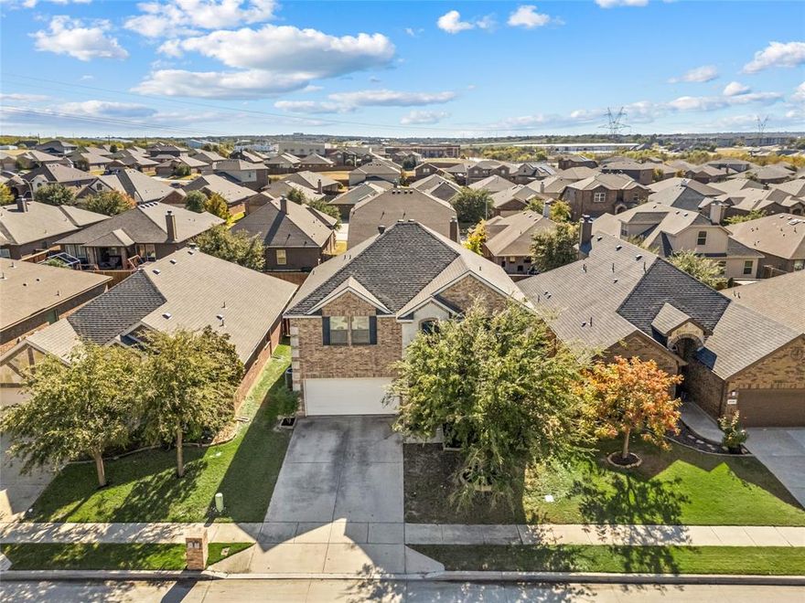 This polished two-story Meritage build is now under 400K, has been beautifully maintained and is ready for its next owners! The layout is fantastic, with the primary suite downstairs, complete with an ensuite bath featuring dual sinks, a separate soaking tub, a walk-in shower, and a large walk-in closet. Hardwood floors run throughout the main level, giving the home a warm, welcoming feel. Upstairs are the secondary bedrooms, all nicely sized and each with its own walk-in closet—a rare find and great for extra storage.  Located in Northwest ISD and on the Byron Nelson High feeder pattern, this home offers both comfort and a great school zoning. Recent Impact resistant roof saves on insurance! Custom crown lighting in Primary and Dining room! Clean, bright, and move-in ready— Do not miss this one.