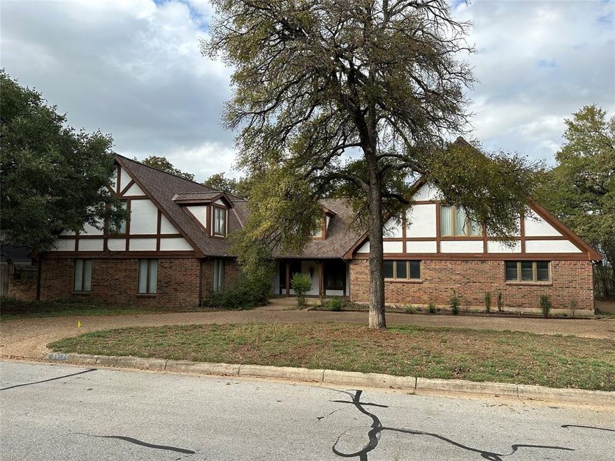 Spacious stately Tudor with tons of potential and an impressive panorama view from the back yard. Perfect for the experienced remodeler looking for a signature project or customize it to suit your needs as your forever home! Property backs to the property that was formerly Woodhaven Country Club.  Excellent location convenient to both 30 and 820.  Home was completely custom and well built with Anderson Windows, Acme Brick and solid wood doors.   Property offered AS-IS, seller to make no repairs.  Property will not qualify for traditional financing programs in its current condition.