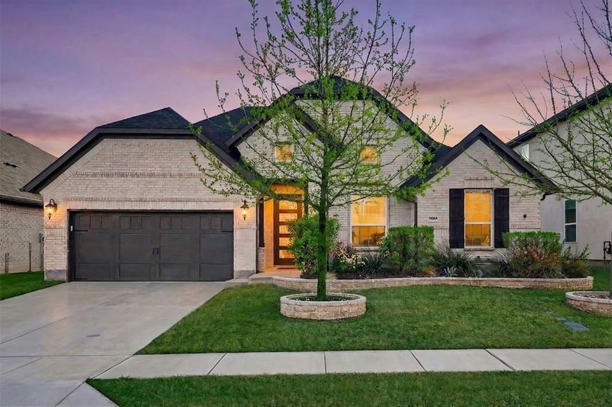 Spacious, well-appointed single-story home in Argyle ISD’s Canyon Falls neighborhood. Thoughtful design delivers an open interior with wide hallways, tray ceilings, and on-trend light wood floors throughout major spaces, creating a seamless flow ideal for everyday living. Off the foyer, a private study with French doors and custom-built-ins offers a dedicated work-from-home space or, with its access to plumbing, makes a great lounge room. The central living area features vertical shiplap above the fireplace and inside built-ins, adding architectural detail and a warm focal point. The adjacent kitchen is appointed with quartz countertops, stainless steel appliances, an apron-front farmhouse sink, five-burner gas cooktop, pot filler, & a large island with a pull-out trash-and-recycling center. It's a perfect gathering space for family and friends.  Bedrooms are arranged in a three-way split configuration for privacy and flexibility. The primary suite boasts direct patio access from the bedroom, while the attached bath offers dual sinks, a frameless shower, and a soaking tub beneath a rain-glass window. Two secondary bedrooms share a full bath, while a third has its own ensuite—ideal for guests or multigenerational living. A powder bath is conveniently located near the living & media rooms for easy access when entertaining. The soundproofed media room is great for movie nights, gaming, or as a versatile flex play room. The utility room features extensive storage, with a shiplap wall including coat hooks, cubbies above and below a built-in bench, and space for an additional refrigerator. Outdoors, the extended covered patio includes ceiling fans, a stone-lined planter, & gas connections for a grill or patio heater. Nice closet space throughout + fully floored, standing height attic. Canyon Falls amenities include pools, splash pad, fitness center, dog park, playgrounds, miles of trails. HOA covers front yard care, cable, and internet. Walk to Argyle South Elementary!