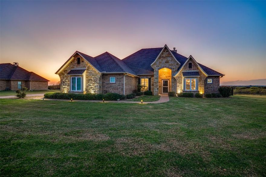 Welcome to your dream home just outside Kaufman, Texas — where custom craftsmanship, modern elegance, & wide-open Texas living come together in perfect harmony. This stunning custom-built residence sits on over an acre of land that extends well beyond the large, fenced yard. It features 3 bedrooms, 2.5 baths, a dedicated home office, 2 dining areas, 2 living areas, & a spacious 3-car garage. The Tudor-inspired exterior boasts beautiful natural stone accents, an extended aggregate drive, & a solid wood speakeasy front door that makes a lasting first impression. Inside, rich ceramic tile with the look of hand-scraped wood flows throughout the home, creating warmth & continuity. The inviting living room centers around a huge stone fireplace, while two dramatic sliding barn doors with translucent glass panels open to reveal a flexible bonus room, perfect for a game room, home gym, or media retreat. Crown molding can be found throughout the home as well as stylish wooden shutters! The chef’s kitchen features a beautifully veined marble island, custom cabinetry, stainless-steel appliances, & elegant pastel tile backsplashes set on the diagonal. The primary suite is a peaceful retreat, complete with a tray ceiling & a luxurious en-suite bath with oversized tub, walk-in shower with custom tile, & dual vanities. Step outside & discover your personal resort, a custom pergola overlooks a sparkling pool & spa, surrounded by the tranquility of open Texas countryside. A powered metal shop provides the perfect space for hobbies, storage, or projects. Located within highly rated Kaufman ISD, this home offers convenient access to major employers, shopping, dining, & nearby highways, making commutes simple while preserving the serenity of country living. Here, you’ll experience the best of both worlds, the peace of small-town TX life & the sophistication of a truly custom-built home. Schedule your private showing today & see why this Kaufman gem is one you’ll want to call your own.
