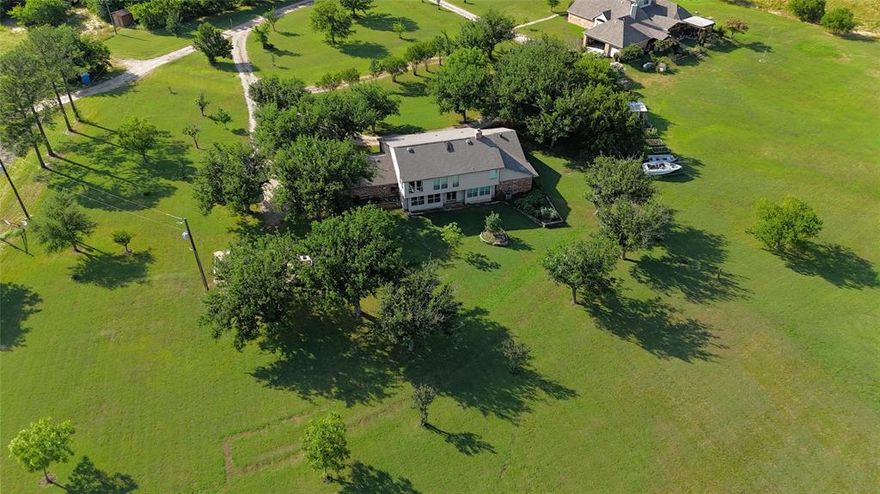 Experience breathtaking views of Lake Lewisville from this secluded 2.48-acre estate, minutes from the Dallas North Tollway, PGA Headquarters and the planned Universal Theme Park in Frisco! This 5-bed, 4-bath home features an open floor plan with bay windows and an upper-level guest suite highlighting the panoramic views of natural beauty.  The manicured lawn with ample shade trees provides the perfect setting for relaxed lakeside living, boating, fishing and outdoor gatherings. This enchanting location is your perfect oasis, blending the tranquility of country life with city convenience!