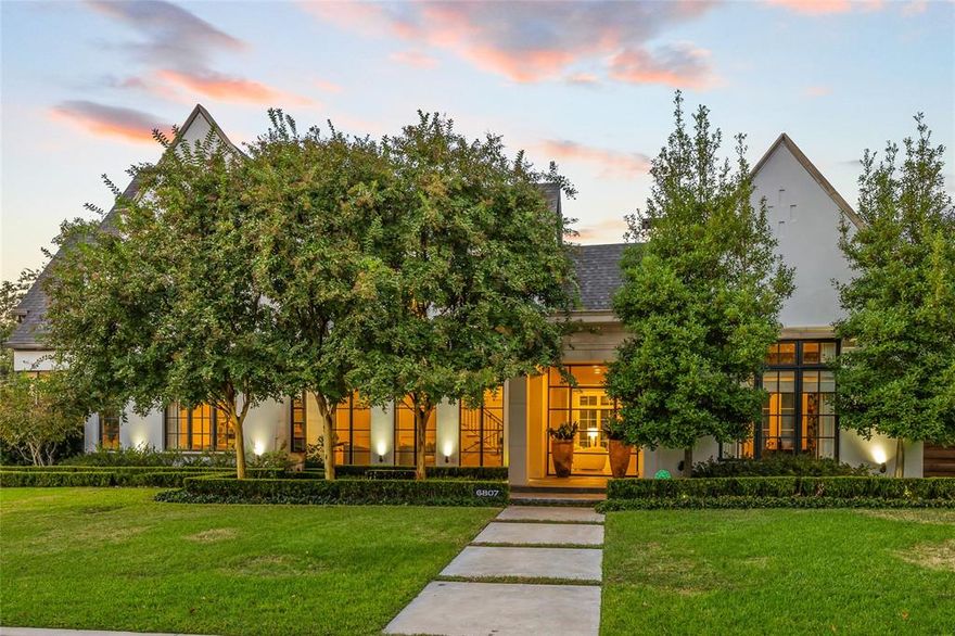 This stunning transitional home, crafted by Robert Elliott Custom Homes and updated by Sees Design, combines style and comfort in 6,680 square feet. Featuring 5 bedrooms, 5.1 bathrooms, and a beautiful outdoor oasis, it’s perfect for both everyday living and entertaining. Flooded with natural light from floor-to-ceiling windows and a custom steel entry door, the home offers a welcoming sitting room and large dining area that leads into a spacious bar. The inviting family room opens to the kitchen and breathtaking backyard. The chef’s kitchen boasts Wolf and Subzero appliances, a walk-in pantry, and a cozy breakfast nook. Downstairs also includes a private study connected to its own peaceful patio, plus a guest suite with a full bath that directly accesses the outdoors. Upstairs, the primary suite offers a spa-like bath with dual vanities, a claw-foot tub, and a large custom closet. Three additional bedrooms, each with an en-suite bath and walk-in closet, a study nook, and a spacious game room complete the second floor. The backyard is a true retreat designed by Archiverde Landscape Architecture and lined with mature magnolia trees. The pool and spa offers a relaxing water feature and a retractable cover. The covered patio, complete with infrared heaters and Haiku fans, is ideal for outdoor dining. The summer kitchen is equipped with all Kalamazoo cabinetry and appliances, including hybrid fire grill, pizza oven, burners and beverage fridge. Additionally, the gas fire pit, ipe decking, Calcutta stone countertops, and steel arbor pergola make it perfect for entertaining. Additional features include a gated driveway, an oversized garage with custom shelving, and a prime location near Preston Hollow Village and North Park Mall. This home offers a seamless blend of elegance and comfort, creating the perfect space for modern living.