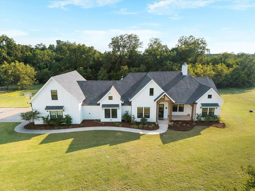 Beautiful 4 bedroom, 3.5 bath home situated on 2 private, fenced acres in the desirable Caddo Mills ISD. This property offers a thoughtful layout and high-end finishes throughout. The main living area features vaulted ceilings and an abundance of natural light. The gourmet kitchen is designed with quartz countertops, custom cabinetry, gas appliances,  opening to a spacious dining area. Kitchen opens up to the living area with vaulted ceiling and decorative wood burning fireplace. A private study, mud bench off the garage entry, and a well-planned laundry room with space for a refrigerator provide both style and functionality. The primary suite is generously sized and includes a spa-like bath with a soaking tub, dual shower heads, and a custom walk-in closet. Secondary bedrooms include one with a private en-suite and two that share a convenient Jack and Jill bath. Upstairs, a large game room offers additional living and entertaining space. Outdoors, mature trees provide a natural green screen for privacy, while the 3-car garage adds ample storage and parking. This property combines elegance, comfort, and modern design in a serene setting.