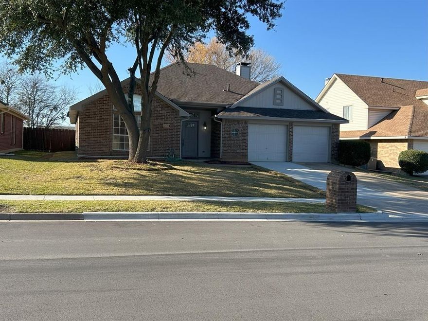 Welcome to this beautifully updated 3-bedroom, 2-bath brick home with a 2-car garage, located in a well-established neighborhood. This move-in ready property features a brand-new roof, new carpet, and fresh paint throughout. The functional floor plan offers two spacious living areas, ideal for both everyday living and entertaining. The kitchen includes an island, a dine-in area, and an over-the-counter serving bar, providing ample space for gathering and convenience. The primary suite features a garden tub, creating a relaxing retreat. The main living area is enhanced by a brick wood-burning fireplace, adding warmth and character. A built-in entertainment system.The backyard offers a tiled patio, mature trees, and a raised planter, along with a generous yard space. A gate provides direct access to an expansive field behind the property, offering additional open space. A pet door with cover is installed in the back door for added convenience. Conveniently located with easy access to I-20 and Highway 360, this home is just minutes from Arlington Highlands, providing a variety of shopping, dining, and entertainment options. Seller(s) offer up to $5k in Closing Cost with accepted offer. Occupied Until April 18.