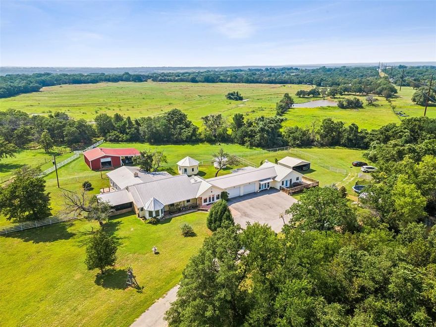 REDUCED!  A GREAT PROPERTY AT A GREAT PRICE!  Your secluded paradise is hidden at the end of a winding driveway! Behind a gated entrance is this perfect housing arrangement with a 4 bedroom, 3.5 bath home that includes a huge office or game room.  Attached is a second residence that completes this perfect setup for a guest house or mother-in-law quarters.  It features 2 bedrooms, 2 baths, and a deck on two sides. The homes are separated with a double garage, & there's also a detached double carport perfect for extended families & guests. The location next to Fossil Rim makes it ideal for an Airbnb or venue. The pool, outdoor kitchen, seasonal creek & fish pond keep everyone busy! The sandy loam terrain is level & perfect for horseback riding. The horses have their 5-stall barn with a large tack rm. There's an octagonal building originally designed for a hot tub but currently used for storage. A large shed off the stall barn would probably park 4 vehicles, and there's an older barn used for storage. Cross-fenced with scattered water faucets for animals or irrigation. Ag exemption.  9.89 acres. SO MUCH...see amenities list in attached docs.