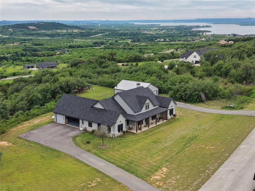 Beautiful hilltop home in the gated hills above Possum Kingdom offering sweeping elevated views of the valley below and an unmatched blend of comfort, space, and functionality. Located in a sought after community with resort style amenities including a boat ramp, fitness center, infinity edge pool, and clubhouse, this property is designed for both everyday living and weekend escapes.

The home features 3 spacious bedrooms, 2.5 baths, a dedicated office, and an additional flex room ideal for a game room, hobby space, or toy room with convenient exterior access. A built in safe room tornado shelter adds peace of mind.

The kitchen is equipped with a Viking commercial range with double oven, creating the perfect space for cooking, hosting, and gathering.

Enjoy sunrise coffee or evening sunsets from the covered front and rear porches while taking in the scenic surroundings. The large attached 3 car garage provides plenty of room for vehicles and storage.

A standout feature is the oversized detached fully insulated shop complete with air conditioning, kitchenette, and full bathroom, making it perfect for projects, entertaining, guest overflow, or storing lake toys and equipment.

If you have been searching for privacy, views, premium amenities, and versatile space near Possum Kingdom, this one delivers.
 Additional 2.26 Acres next door (lot 327) is available for purchase with the home