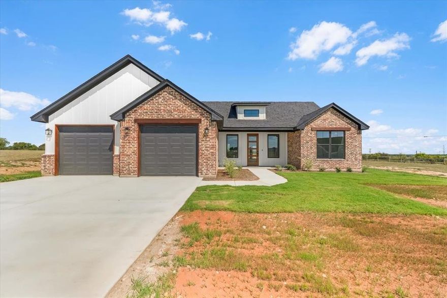 Set on over two acres in Sunset Ridge, this brand-new 3-bedroom, 2-bathroom, 1,640 sq ft home delivers the rare balance of modern style, rural independence, and incredible value in today’s market. Built by White Tree Custom Homes, this thoughtfully designed home offers privacy, flexibility, & the freedom of living without HOA restrictions, all while being minutes to Weatherford or Granbury & zoned to highly regarded Weatherford ISD. Exterior features blend traditional brick with modern accents, creating the perfect mix of country character & contemporary flair. Inside, the open-concept layout maximizes space, giving the home a larger feel than its square footage suggests. Soaring ceilings & stained concrete floors throughout—stylish, durable & incredibly easy to maintain—create a sense of openness & flow. The kitchen is a true highlight, boasting quartz countertops, upgraded shaker-style cabinetry throughout, modern fixtures, and a dining area with a beautiful backyard view. The primary suite retreat offers a spa-like bath with dual vanities, a walk-in shower, and a large soaking tub perfect for unwinding. Secondary bedrooms are generously sized with oversized closets, and ample storage is seamlessly integrated throughout the home. Outdoors, a covered patio overlooks expansive prairie views, offering endless possibilities for a pool, shop, or your own private retreat. Every thoughtful detail—from the upgraded hardware & insulation to the soft rounded edges of the walls & the enhanced storm windows—reflects the impeccable workmanship & pride this builder is known for. A private water well & an aerobic septic system with a 2-year service agreement included add lasting reliability. Buyers will also enjoy the peace of mind of a phenomenal StrucSure warranty—one of the nations best home warranty programs—including a 10-year structural guarantee. Major builder incentive by using their preferred lender & receive a limited-time 4.99% interest rate when approved! Call today!