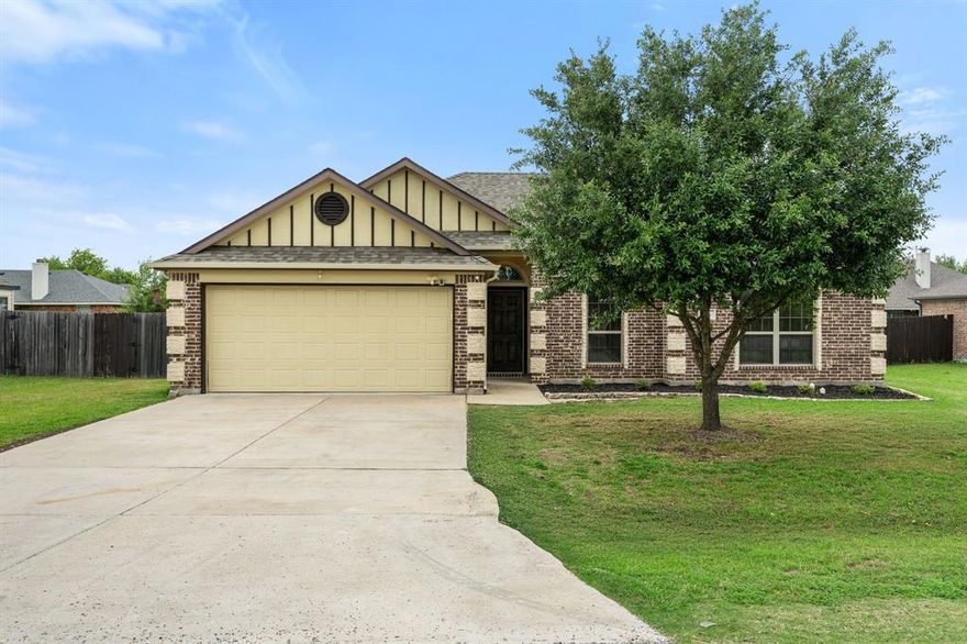 Welcome to the home you’ve been dreaming of, nestled in the heart of Palmer within the highly sought after and top rated Palmer ISD. This beautifully maintained 3 bedroom, 2 bathroom home sits on a quiet, treed lot in the Meadows of Palmer and features a warm, inviting open floor plan filled with character. The kitchen is the true heart of the home with a large wraparound granite breakfast bar, abundant cabinetry, side pantry, tile backsplash, built in microwave, and tile flooring, all seamlessly open to the living and dining areas, perfect for gathering with family and friends. The spacious living room offers a cozy wood burning fireplace, large windows for incredible natural light, and durable wood look vinyl flooring. The private primary suite is a relaxing retreat with a huge walk in closet, double sinks, garden tub, and a stunning glass enclosed shower with pebble flooring. Two additional bedrooms and a full bath are located down the hall, offering comfort and flexibility. Step outside to a large fenced backyard with a covered patio and storage shed, ideal for entertaining, pets, or play. Complete with a 2 car front entry garage, this home truly has it all. Schedule your showing today and come experience it in person!