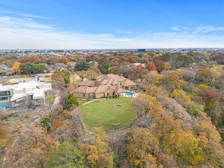 Experience resort-style living in this luxurious, gated estate on 2.25 acres of breathtaking, water-fronted lands just minutes away from Globe Life Field and AT&T Stadium! Whether you’re looking for peace and relaxation, the perfect spot to entertain, or both, head to the infinity pool, spa, fireplace, and private deck in the backyard paradise. Step through these iron doors to the private study or the primary suite, featuring a fireplace, custom walk-in closet, and hidden room. Enjoy the chef's kitchen at mealtime, including a sub-zero fridge amidst a quartzite island with a full butlers' pantry hidden in plain sight. Take the elevator or grand staircase upstairs to find two ensuite bedrooms graced with a wet bar before concluding evenings out upon the balcony admiring starlit night skies…the perfect retreat awaits!