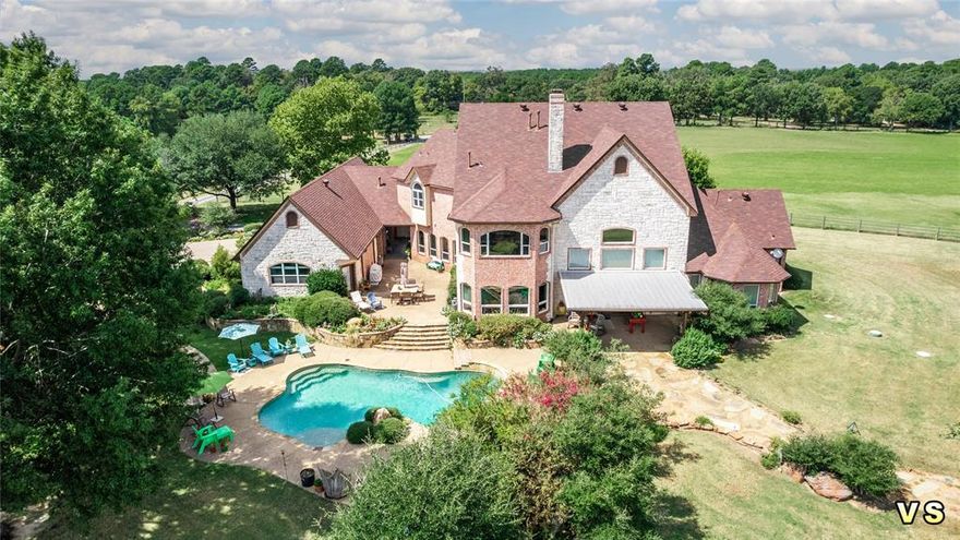 Welcome to your dream estate, an expansive 300-acre property designed for luxury and leisure. The main residence boasts 5,110 sq. ft. The exterior features brick and rock accents, a covered patio, and an open patio leading to the pool house. Enjoy cozy evenings in a grand living room with hardwood floors, large wood beams, a rock fireplace, and a decorative grand staircase. The study has a stunning 14' ceiling. The kitchen is equipped with Wolf stove, KitchenAid appliances, double fridges, and elegant countertops. The master bedroom features high ceilings, bay window, and ensuite bath with oversized closets. Upstairs includes a cozy sitting area, balcony, and two spacious bedrooms with Jack & Jill bath. The estate has a swimming pool with waterfall, extensive landscaping, and a 5,400 sq. ft. barn with air-conditioned areas and ample storage. The property has a 9-acre, 25-foot-deep lake, wooded areas, and Bermuda hay fields. This property offers endless possibilities for luxury living.