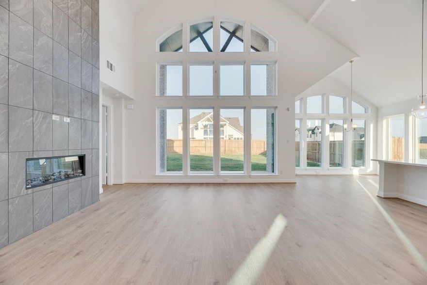 Introducing a stunning new Grand Home in the desirable Park Trails community, ideally located across from Opportunity Central. This beautifully designed Modern Farmhouse Grand Riverside floor plan is the same floor plan as the model home and showcases exceptional attention to detail. The home features a dramatic vaulted family room with a striking two-story modern fireplace and pre-wired flat screen TV outlet. Rich wood flooring extends through the entry, family room, home office, kitchen, and dining area, creating a warm and elegant flow. The gourmet kitchen is a chef’s dream, featuring Shaker-style cabinetry, Omegastone slab countertops, a five-burner gas cooktop with a sleek stainless steel & glass vent hood, built-in stainless appliances, pendant-lit island, walk-in pantry, and a custom trash drawer. A full oak staircase with contemporary wrought iron balusters adds a sophisticated touch. The first floor includes a media room perfect for entertaining, along with a flexible space ideal as a guest suite or private office. Thoughtful upgrades include double front entry doors, eight-foot interior doors on the main level, extensive moldings, rocker switches, and decorative lighting throughout. The primary bath offers a luxurious retreat with a freestanding soaking tub, large walk-in shower, and modern rectangular sinks. Upstairs, a spacious game room provides an ideal area for kids or recreation. A covered back patio offers outdoor living space for relaxation or entertaining. This Energy Star certified home features R38 insulation, a radiant barrier roof, and energy-efficient vinyl windows. Residents enjoy access to a community pool and scenic walking trails, with all local schools within walking or biking distance. This is luxury living with convenience and style in one of the area's most sought-after neighborhoods.