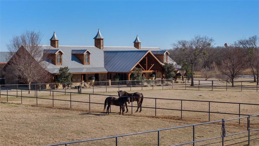 Spectacular Luxury Private Gated Retreat Minutes from the City: Authentic Farm and World Class Equestrian Estate Property on sprawling 50.28 acres (Tax) with expansive scenic views. Interiors with soaring ceilings, gourmet Kitchen with custom cabinetry and Scullery, Great Room and sophisticated Library with fireplace, entertaining rooms. Classic modern amenities throughout the home with wide wood plank flooring, luxury finishes throughout and custom designed bedroom and bathrooms with a showroom worthy walk in Primary Closet. Interiors reflect magazine quality designer luxury features. Two separate Garages with a 2 car and 3 car Garage. The grounds feature Main Horse Barn, Storage Barn with 2 separate living Quarters, Outdoor Open Horse Arena, Covered Lighted Horse Arena, Mare Barn, Covered Horse Jumping Station, Workshop, Chicken Coop, four Ponds; some stocked with Bass fish and Crappie fish for fishing. Main House includes Entry Hall with reception seating area, Library, Living Great Room with double-sided stone fireplace to Dining Room and Updated custom Kitchen with Island, open Breakfast Room seating area and Dining Area. Amenities abound with Game Room with Bar and Media Theatre and separate Guest Suites. Separate Storage Barn with Living Quarters and Laundry Room in Horse Stable Barn and Storage Barn. The Outdoors is relaxing with scenic entertaining areas with covered and open porches, outdoor Kitchen and Bar and custom designed Lamberts Pool strategically overlooking the horizon and built with multi-level water features into the property, Hot Tub and Outdoor Firepit. The right location: Equally close to Dallas as Fort Worth; approximately, under 45 minutes away.  Exclusive retreat, ultra-luxurious residential amenities, state-of-the-art horse facilities and acreage.