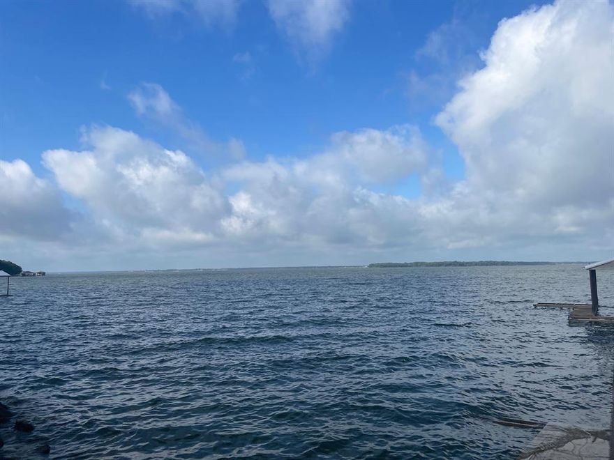 Breathtaking 1.53 acre waterfront homesite! Nestled along the serene shoreline, this spacious tract offers the rare opportunity to own open waterfront with outstanding views. With over an acre of gently sloping, mostly clear land, this property provides the perfect canvas for your dream home or weekend getaway.  The property offers a western orientation on the lake, perfect for enjoying gorgeous sunsets over the water.  Property does have an older single slip boathouse, electric is connected at the property and the lot boasts about 168 feet of shoreline.  Seller has already paid for a soil study and the 320' elevation is marked. Whether you're seeking peace and privacy or a stunning setting for entertaining, this property combines natural beauty with boundless potential. This tract is not located in a deed restricted subdivision, so no HOA, but is still subject to Lake Planning & Zoning guidelines.  Don't miss out!  See this one!