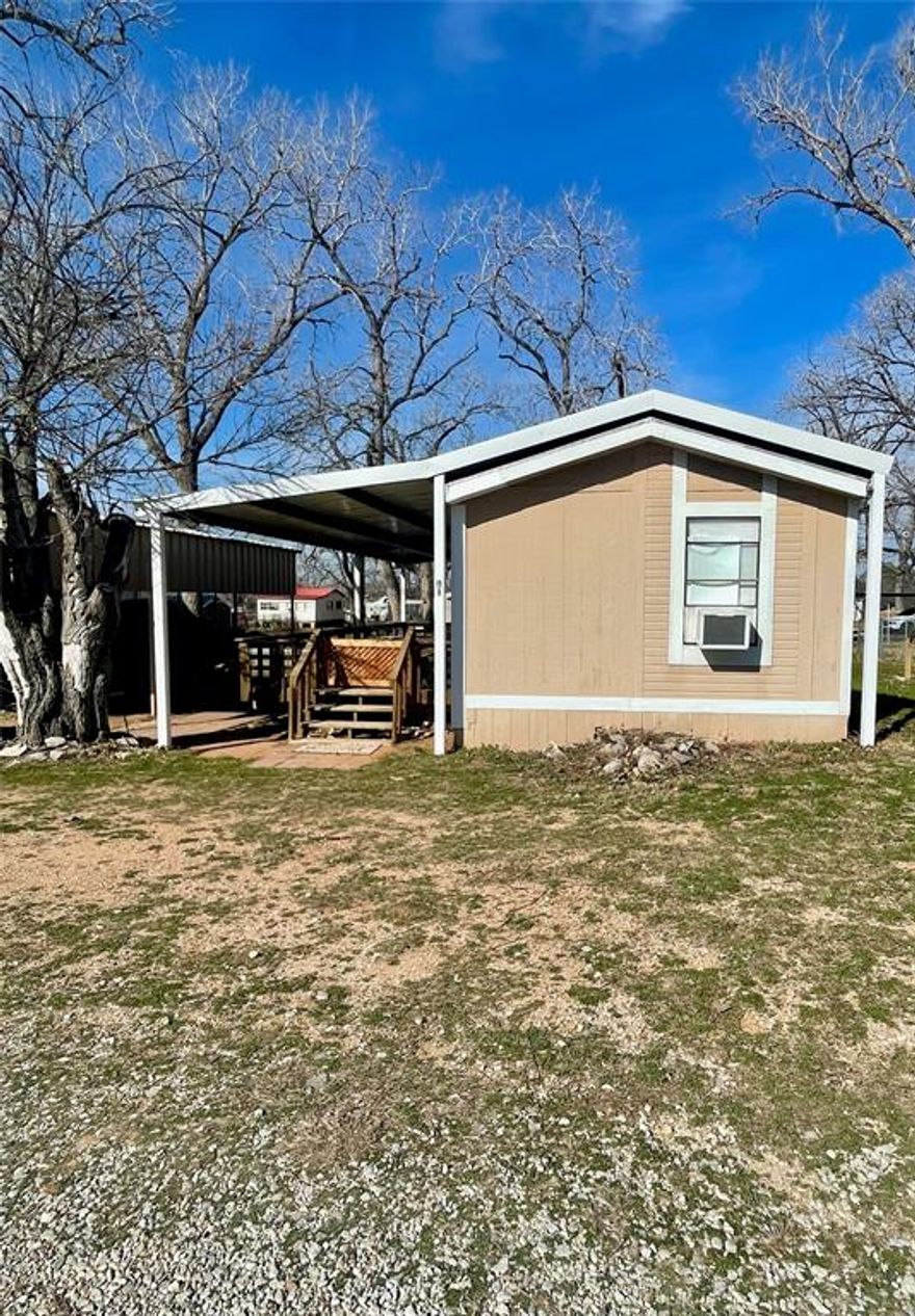 LESS THAN 5 MINUTES FROM THE BOAT RAMP at Willow Beach on the east side of Possum Kingdom Lake. Great place to start your lake life memories! Located within easy walking distance to Willow Beach with access to the community boat ramp and the community store. This property has great shade trees, covered parking for your car and boat, and a fenced yard.  Recent updates include metal covering over home and deck, new shower, subfloors replaced in kitchen hallway and bathroom, new electric water heater in 2024.  Property will come furnished ~ just add your personal touch and be prepared to relax, have fun, and enjoy the PK Lake Life!
This is a leased land property with an annual lot lease fee of $5950; land owner pays the property taxes on the lot, homeowner is only responsible for property taxes on the improvements.