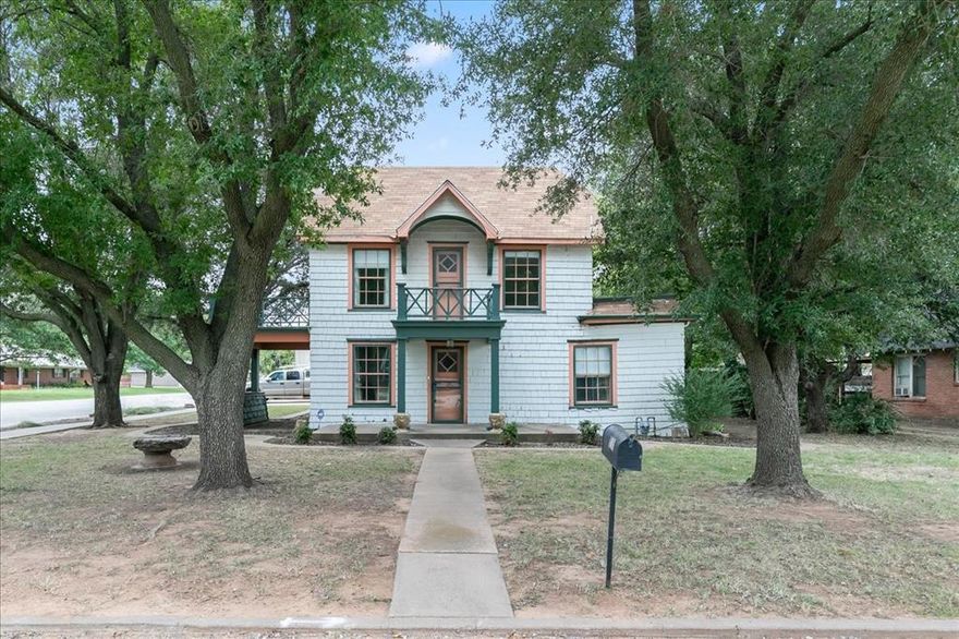 Discover a unique piece of Henrietta, TX real estate with this charming, character-filled home situated on a corner lot framed by mature shade trees. The exterior presents a picturesque first impression, featuring classic architecture with light siding and contrasting trim, a welcoming covered entry, and a quaint second-story balcony. The home offers 3 generously sized bedrooms and 2.5 bathrooms, plus a detached garage. 

The interior boasts beautiful dark wood flooring throughout, creating a warm and cohesive aesthetic. Multiple living spaces offer flexibility and light, including a sunroom with an abundance of windows, perfect for relaxation & perfect home library or office with built-in shelving. The dining area includes charming built-in cabinetry and ample natural light, flowing into a spacious kitchen featuring extensive white cabinetry, and ample counter space. 

In the backyard you will find a pergola area ideal for relaxing or entertaining, and multiple raised flower beds just waiting for a green thumb.

This distinctive property combines historic style with functional living spaces, perfect for a family or anyone seeking character and comfort.