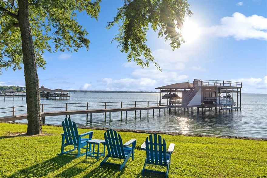 Experience the epitome of Texas lake living at this mature treed, 2.62-acre waterfront home located in a gated community on Richland Chambers. Begin your day waking up to TX Sunrises & enjoy endless outdoor space that showcases 180-degree views, 335 ft water frontage, custom built & maximum limit boat dock, with 3 slips & rooftop. One-of-a-kind pristine home features 4 fireplaces, vaulted 2 story ceilings & large, picturesque windows which frame the views & provide natural light. Chef’s kitchen boasts Viking appliances, large island & provides ample storage. 1st floor primary suite opens to lake views, double walk-in closets & jetted tub & large shower. Estate sleeps 18 comfortably & entertaining is a breeze with multiple living spaces, bunk room & deep multi-level deck for lounging & relaxing. Perfect home for living, entertaining, fishing, water sports & dining alfresco while watching the sunset. A quick 90 minutes from Dallas. All furniture and lake toys can convey with property.