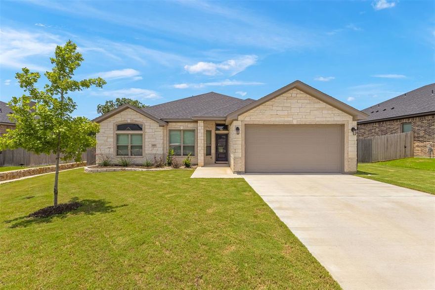 Stunning 4-Bedroom Home with Spa-Like Primary Bath & Designer Finishes! Step into comfort and style in this beautifully appointed 4-bedroom, 2-bath home offering 2,140 square feet of thoughtfully designed living space. From its inviting curb appeal to the serene backyard retreat, every detail of this home blends luxury and functionality. The spacious family room is the heart of the home, featuring eye-catching wood-beamed ceilings, a cozy wood-burning fireplace with an elegant tiled surround, and an ornate mantel that creates a warm, welcoming atmosphere. The open-concept layout flows seamlessly into the modern kitchen, where you’ll find granite countertops, designer backsplash and upscale accents, custom soft-close Shaker cabinets, built-in oven and microwave, a sleek cooktop with vent hood, and a powered granite-topped breakfast bar perfect for casual meals. Enjoy your morning coffee in the breakfast area overlooking the private backyard.  Retreat to the spa-like primary suite, where vaulted ceilings and abundant natural light create an airy, relaxing vibe. The luxurious ensuite bath boasts a dual-entry walk-in shower, garden tub, and separate opposing vanities—designed to elevate your daily routine. The split bedroom floorplan has three guest bedrooms and a full guest bathroom on the other side of the home, maximizing privacy. Additional features include spray foam insulation for energy efficiency, crown molding, wood-look ceramic tile flooring in main areas, ceiling fans, and a 2-car garage. Enjoy outdoor living in the beautifully landscaped backyard, complete with a privacy fence, covered back patio, and an automatic sprinkler system to keep your lawn looking its best year-round. Conveniently located near Baylor Scott & White, shopping, dining, and easy access to I-35, this home combines modern comfort with everyday convenience. Don’t miss your opportunity to own this exceptional home—schedule your private showing today!