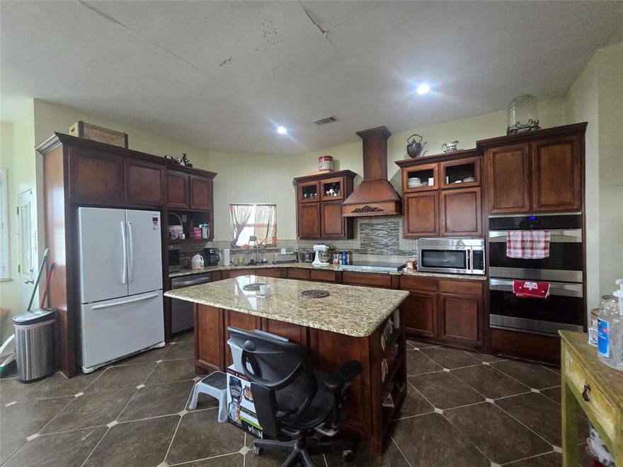 4,192 sq ft Custom Home on 2.256 Acres - Mid-Construction Opportunity with Shop Slab already in place! Opportunity awaits on 2.268 acres outside the city limits of Red Oak with this 4,192 sq. ft. home built in 2005 - a rare chance for the right buyer to finish a large custom home exactly the way they want. This property makes a strong first impression with an expansive covered front porch that wraps around to the side, classic porte-cochere, and a detached two-car garage. An additional 30' x 60' slab has already been poured to add a future workshop, barn, or additional building. Inside, the home was designed with entertaining and a large family in mind. The huge kitchen features gorgeous custom cabinetry, a massive island, and it's open to the large dining area with fireplace and built in buffet, creating a spacious central gathering space. This home is mid-project and will require interior completion, making it an excellent opportunity for investors, builders, or buyers looking to create a custom home with built-in equity. Many construction materials have already been purchased and will convey, helping reduce the cost and timeline for finishing the project. A new roof was installed in 2024, adding additional value and peace of mind. Engineered wood flooring installed throughout most of the downstairs. 3 bedrooms and 3 full bath downstairs with an office and two other flex rooms great for exercise room, project or craft room. Dual primary bedrooms feature ensuite baths and can be used for in-laws. Upstairs is incomplete but features a build-out already framed for a game room, media room, and bath. With over 4,000 square feet of living space, acreage for privacy, and major structural elements already completed, this property offers incredible upside potential for someone ready to bring the vision to life.