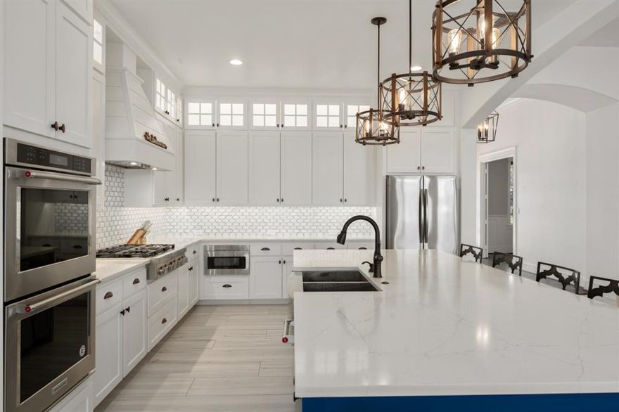 Experience the ultimate in lakeside luxury with this stunning 4-bedroom, 4.5-bathroom waterfront home, designed for those who love to entertain and unwind. The heart of the home is an expansive open floor plan where the living and dining areas feature breathtaking wall-to-wall windows, offering an unobstructed view of the water. Directly inside the front door you will find the office area for those who work from home. The gourmet kitchen is a chef’s dream, equipped with a KitchenAid gas cooktop, double ovens, a wine fridge, and a dedicated ice maker. Three of the bedrooms serve as a private retreat with their own ensuite bath, a spacious bunk room is directly adjacent to a hall bathroom. A massive primary suite and ensuite bath features double vanities, a soaking tub, and a custom-designed closet. Open the window coverings in the primary suite and view the lake in the mornings from bed. Above the 3-car garage, a large bonus room—currently a game room—adds the perfect space for recreation, while the impressive utility room offers a sink, folding area, and extra fridge for ultimate convenience. The outdoor amenities are equally spectacular, featuring a covered patio with retractable screens, a full outdoor kitchen, and a cozy fire pit for lakeside evenings. No need to worry about the electricity going out with a GENERAC connected to the home! The large storage shed allows room for lawn tools, boat toys and comes with the refrigerator to keep all the fish you catch fresh until it's time to eat!  Walk down to the private dock to swim, fish, or launch your boat from the electric lift, which comes complete with a protective cover. Best of all, everything in the home conveys with the sale (there are a few things in exclusions) allowing you to start living the lake life the moment you receive the keys!