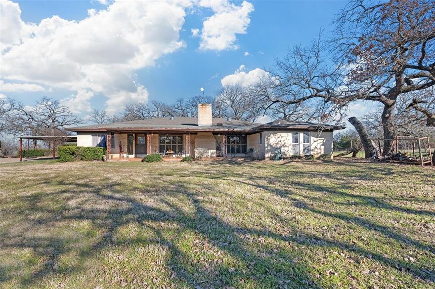 This is your opportunity to own a rare 18.29 acres in Burleson with a 3100 sq ft home! This home is situated towards the back of the property and features an electric gate which makes it more private. Upon entry you will find a very large living area complete with wood burning fireplace and plenty of room for everyone! Kitchen is large and features a breakfast area with large bank of windows. Breakfast bar, built ins, & such a great space to prepare meals! The primary features 2 full baths and is very large both with walk in showers and one bath has a giant walk in closet. Each secondary bedroom has its own bath. Office by front entry is perfect for paying bills or working from home! The acreage is heavily treed and an additional 2700 sq ft building for storage or workshop and has electricity! This home has so much potential and it faces FM 731 so there is possibility portions could be rezoned commercial!
