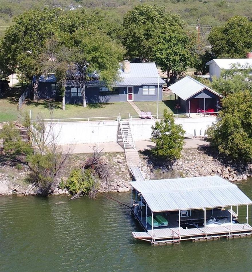 This Lakeside escape is a hidden gem! Whether you're seeking a peaceful getaway or an adventurous lakeside experience, this 4 bedroom lake house is the perfect place for a picturesque retreat. Fully furnished all the way down to utensils, this turn key property is also an established successful air b&b. Nestled on the serene shores of Coleman Lake this property boasts a large dock located in good water with breathtaking views of the surrounding natural beauty. Perfect for water enthusiasts, you can spend your days swimming, boating, fishing, bird watching or simply basking in the tranquility of the lake. Inside, the house is tastefully furnished. The 4 well-appointed bedrooms ensure a good night's sleep after a day of exploration. Gather around the cozy fireplace or enjoy a game of ping pong. The fully-equipped kitchen with granite countertops allows you to prepare delicious meals. Come & create unforgettable memories in this hidden gem, where stunning views and water adventures await.