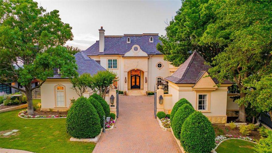 Welcome to this stunning Mira Vista estate located in the heart of Fort Worth, Texas. This exquisite French chateau home boasts over 8,000 square feet of luxurious living space, including 4 bedrooms & 6 baths as well as an office, media room, wine cellar & solarium. From the moment you step through the private gates, you’ll be transported to a world of elegance & sophistication. The main living areas are perfect for entertaining with soaring ceilings, intricate moldings, well-crafted finishes, vast windows, & marble flooring. The formal living room is perfect for hosting parties, while the chef’s kitchen extends into the den providing warmth & hospitality. From there, the primary suite is a true retreat, with a fireplace, sitting area & a French spa-like bathroom. Each of the additional bedrooms is generously sized & features own ensuites. Then outside, the multiple patios provide views extending for miles in every direction & overlook the lush garden backing up to the golf course.