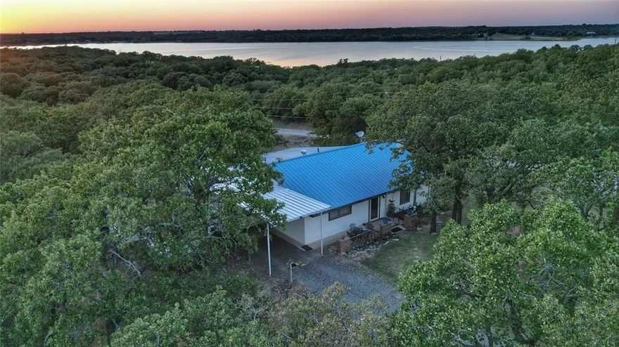 Escape to your lake retreat in gated Nocona Hills! Imagine waking up to the breathtaking views of the Lake from this charming move-in-ready 2-bedroom, 2-bathroom home nestled on nearly 1 full acre across three combined lots. This expansive corner property is surrounded by lush mature trees. 3+- lots totaling approximately 0.94+-acres allows extra privacy & elbow room offer rare space & seclusion in the secure gated community of Nocona Hills. Step inside to a bright & inviting living room flooded with natural light through large picture windows & warmed by a cozy wood-burning fireplace perfect for relaxing evenings. The well-equipped kitchen boasts modern appliances, plenty of cabinetry, & generous counter & space seamless flow into informal dining & spacious versatile pantry. The primary suite features a walk-in closet & private en-suite bath, while the comfortable second bedroom with 2 closets enjoys easy access to a convenient 3-piece hall bath with linen storage. Outdoors, unwind on the covered back deck with your morning coffee or evening drink soaking in the peaceful lake views & spotting wildlife. Hobbyists & do-it-yourselfers will appreciate the two detached sheds with electricity, built-in workbenches, & shelving. Seller to provide a home warranty.There is plenty of room under the oversized carport for all your outdoor toys, complete with full RV hookup. Exciting things are happening in Nocona Hills! The community is buzzing with potential positive improvements to perhaps renovate existing clubhouse, a 19th Hole, & Pro Shop with hopes to open soon, & bringing back golf tournaments on the scenic 18-hole course. Minutes from charming Nocona for shopping, dining, entertainment, nearby wineries & local eats. Quick access to Oklahoma casinos across the Red River bridge. Schedule a showing today & make it yours! Access with agent only. Motivated seller. Survey of one lot purchased separately would need to be completed to determine exact size of total property.