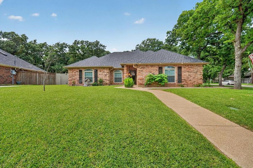 Beautifully updated 3 bedroom, 2 bath home nestled on a spacious corner lot shaded by mature trees in an established Burleson neighborhood! This inviting home features rich hardwood floors, elegant tray ceilings and a warm open-concept living area centered around a stunning brick fireplace. The remodeled kitchen offers granite countertops, stainless steel appliances, abundant cabinetry and stylish backsplash accents, flowing seamlessly into the bright dining area surrounded by windows and natural light.

Private primary suite includes hardwood flooring, dual vanities, soaking tub, oversized walk-in shower and two walk-in closets. Split secondary bedrooms provide added privacy and flexibility for family, guests or a home office. Step outside to enjoy the oversized covered patio perfect for relaxing or entertaining, plus a large backyard complete with storage shed, mature trees and additional fenced area ideal for pets or hobbies. Conveniently located near shopping, dining and schools with easy access to major highways. This move-in ready home offers charm, updates and plenty of outdoor space!