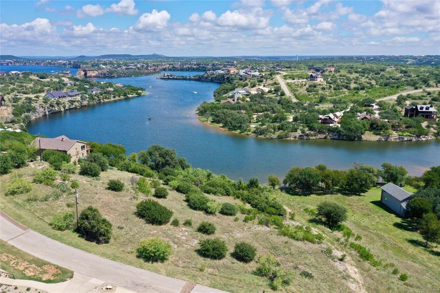 This just under one acre lot at Possum Kingdom Lake gives you one of the most iconic views around with a perfect angle looking straight at the back of Hells Gate. Not only do you get the views but you also have direct access to the waterline, making it easy to enjoy all the lake has to offer. The property is located in a gated community with top notch amenities that add to the lake life experience. You can cool off at the community pool, launch from the marina, or saddle up at the horse facilities. Tennis courts and a general store are right inside the neighborhood along with a pavilion for gatherings. Whether you are looking to build a weekend retreat, a short term rental or a full time lake home, this property is a rare find with views, water access, and a community built for relaxation and recreation.