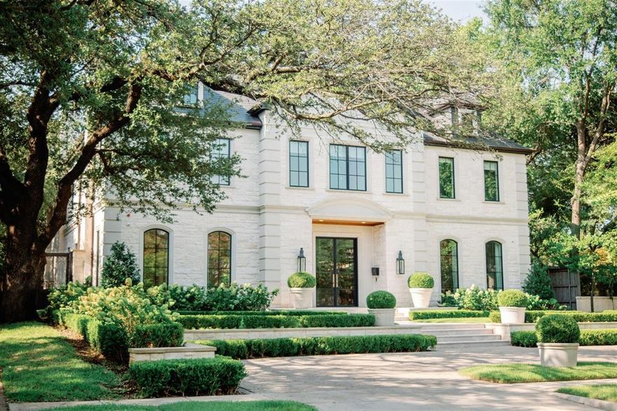 Elegant French transitional located in Dallas' most sought-after neighborhood, characterized by tree-lined streets, charming parks, the DCC, and the renowned Highland Park Village for upscale shopping and dining. This 5-bedroom, 7-bathroom home, designed by Richard Drummond Davis and built by Colby Craig Homes, seamlessly blends classic sophistication with modern luxury. Stately white stone exterior, with cast stone details, slate tile roof, glass and iron front doors, gas lanterns, and a circular driveway create a lasting impression. The sophisticated foyer features a sweeping spiral staircase, custom wainscoting, designer light fixtures, hand-carved marble fireplaces, and a 1,000 bottle glass wine vault. The expansive great room, perfect for entertaining, opens to the gourmet kitchen with Wolf Sub-Zero appliances, dual dishwashers, wine column, steam oven, white Macaubas quartzite countertops, a waterfall island, and refined brass hardware. The primary suite includes a private office, floor-to-ceiling fireplace, free-standing tub, custom closet, and marble island. The outdoor space boasts a spacious covered patio with a fireplace, summer kitchen, and direct bath access. Surrounded by lush boxwood greenery and pristine turf, the boutique-style pool features eye-catching blue tiles and a built-in retractable safety cover. Additional highlights include a game room, private office off kitchen, Lutron smart home system, back staircase, and elevator.