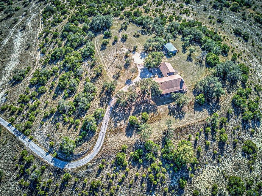 AUSTIN HILL COUNTRY LEGACY RANCH UNRESTRICTED 19.15 ACRES with LIVE WATER. NEWLY COMBINED AND PRICED AT $2,000,000. This is a generational opportunity to own 19.15 fully unrestricted acres situated across two counties (Burnet and Blanco), offering ultimate privacy and self-sufficiency just minutes from Spicewood and Austin. The price is firmly aligned with the unique, high-value features this property delivers. UNBEATABLE VALUE PROPOSITION: ZERO Restrictions. No HOA, no zoning. Build the custom estate or establish the Ag Exemption of your dreams (buyer action required upon closing). Natural Riches Included. Features a rare Natural Spring-fed Pond and Half of the Mineral Rights will convey, providing valuable water resources and significant long-term potential. Convenience Advantage. Located atop a private hill at 414 Hall Lane, this retreat offers seclusion while maintaining easy access to Highway 71 and the thriving city of Austin. TURNKEY HOME & UPGRADED SYSTEMS: Charming 1,467 SF log home (3-bed,2-bath) with a cozy wood-burning fireplace equipped with an electric fan. Enjoy serene Hill Country views from the full-length covered porch (350 SF). Includes an attached 2-car garage (616 SF) with a 2-car paved drive, a covered breezeway (84 SF), and a 200 SF insulated workshop with utilities and heat lamps. System Certainty: Recent upgrades include a New HVAC system and New water well equipment (new pipes, bladder,compressor, and impeller) eliminating immediate capital expense for the buyer. LAND & RANCH DETAILS (19.15 Total Acres): Majestic Live Oak trees, gravel road access, and partial perimeter fencing (approximately two-thirds to three-quarters complete). Wildlife includes one deer stand with timed feeders and two game cameras, appealing to recreational buyers.