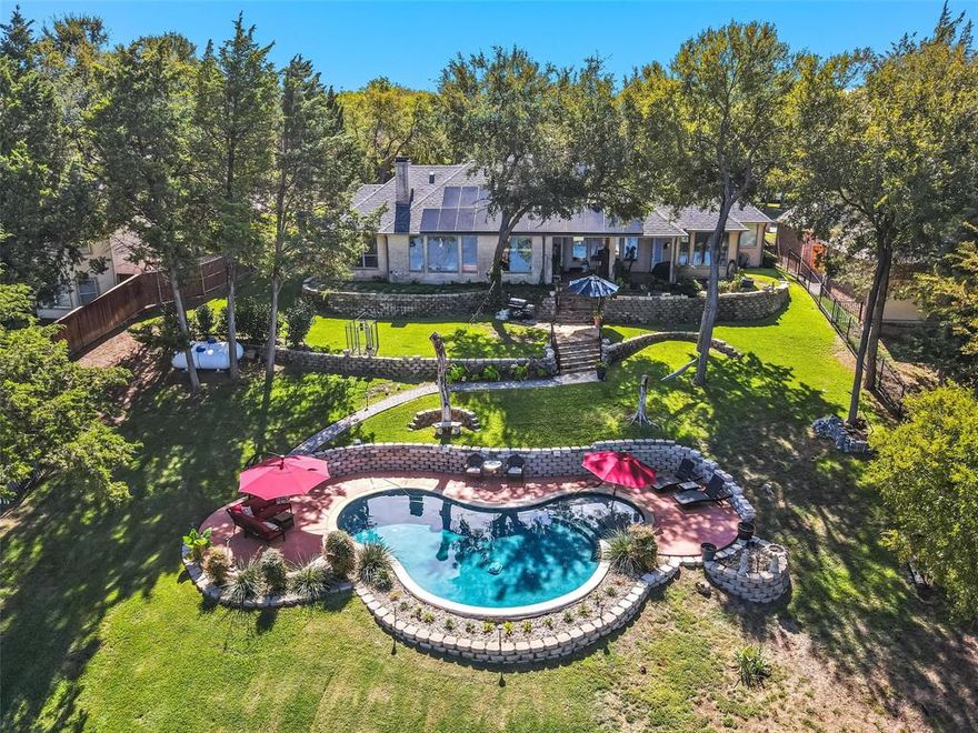 Rural water front living in close proximity to the city. This meticulously crafted custom home is a splendid fusion of French-inspired design and modern comfort. The open floor plan encompasses formal living and dining areas, large family room with a fireplace & wet bar, and a spacious island kitchen featuring a prep island, ample cabinetry, granite countertops & exquisite travertine backsplash. A wall of windows brings plenty of natural light and views of the lush backyard. The home boasts numerous upgrades, including porcelain tile, hardwood flooring, and plantation shutters. In addition, the master bathroom has been updated with modern fixtures and finishes. Over one acre, the backyard has three distinct levels. The first level features the house with a charming covered patio. Moving down to the second level, you have a stunning pool area. Finally, the bottom level is a hidden gem, bordering a private six-acre lake, offering tranquility and an exceptional connection to nature.