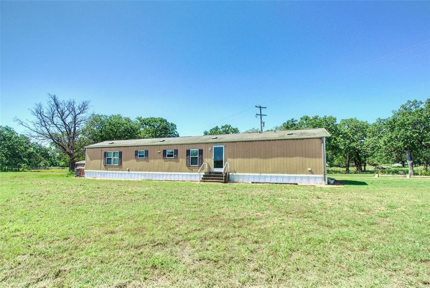 Set on a full acre in Marlin, Texas, this 2013 single-wide manufactured home offers 3 bedrooms and 2 bathrooms with a smart, comfortable layout. The primary suite features walk-in closets and an ensuite bath with double vanity sinks, creating a private retreat. Outside, the property includes two covered carports, a storage shed, and a fully fenced backyard—perfect for pets, gardening, or outdoor relaxation. With plenty of space and useful features both inside and out, this home is a great opportunity for anyone looking for affordable country living with modern comforts.
